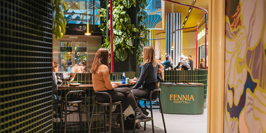 Kaksi tyttöä keskustelee Fennia-korttelin ravintolamaailmassa.